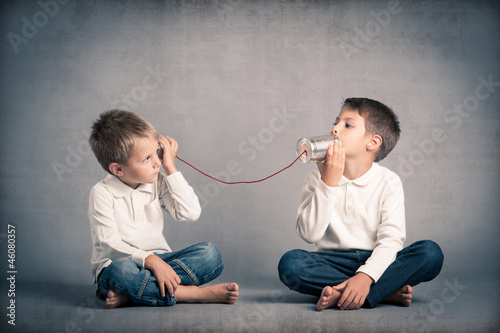Young brothers talking with tin can telephone
