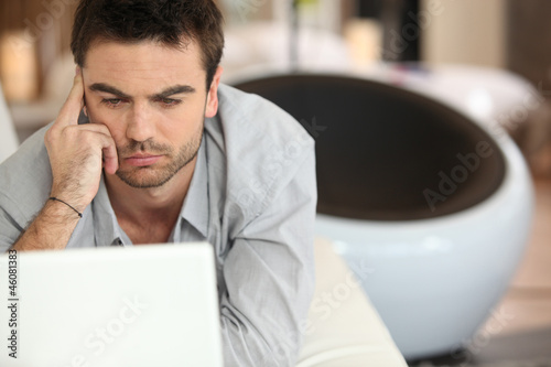 Photo: Puzzled man sitting at laptop Puzzled man sitting at laptop