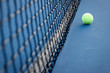 Tennis Ball next to a Tennis Net