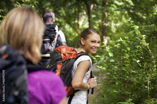 Photo: people with backpack doing trekking in wood people with backpack doing trekking in wood