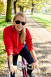 Happy woman cycling on bicycle, autumn in city