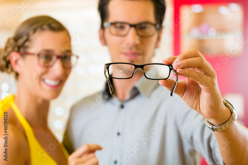 Photo: Young couple at optician with glasses Young couple at optician with glasses
