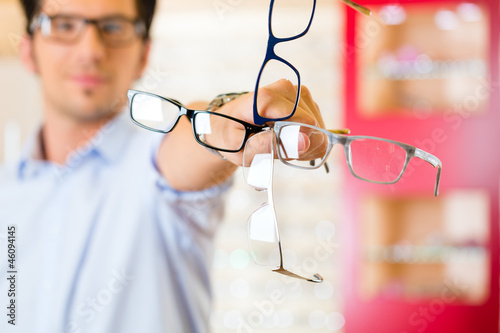 Photo: Young man at optician with glasses Young man at optician with glasses