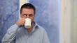 Adult Man in Pensive Mood Drinks Cup of Coffee