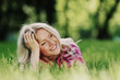 blonde lying on green grass