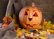 halloween pumpkin and autumn leaves, on wooden background