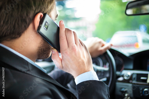 Photo: Man talking on the phone on his car Man talking on the phone on his car