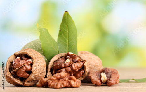 Photo: walnuts with green leaves, on green background walnuts with green leaves, on green background