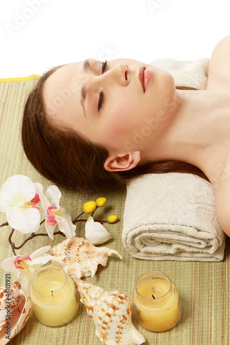Photo: A young woman is lying during a spa treatment on a towel A young woman is lying during a spa treatment on a towel