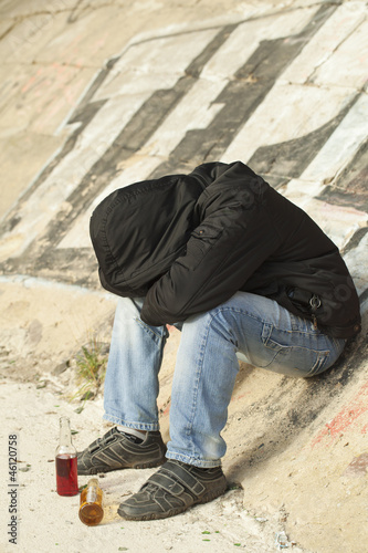 Photo: Boy sleeping under a bridge with two drink bottles near Boy sleeping under a bridge with two drink bottles near
