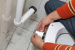 Plumber fixing plastic tube, wall mounted toilet cistern
