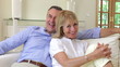 Senior Couple Sitting On Sofa Together