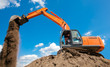 Photo: Excavator with metal tracks unloading soil at construction site Excavator with metal tracks unloading soil at construction site