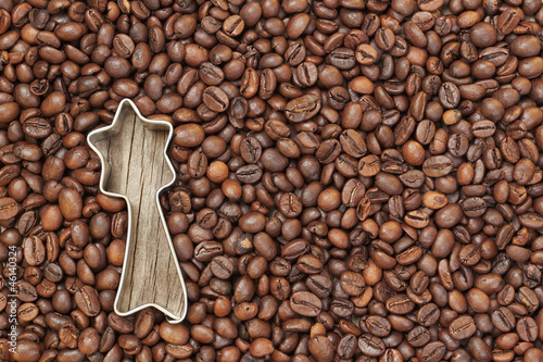 Photo: Shape of a Christmas star in coffee beans on a wooden texture. Shape of a Christmas star in coffee beans on a wooden texture.