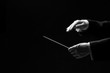 Hands of a conductor isolated on black background