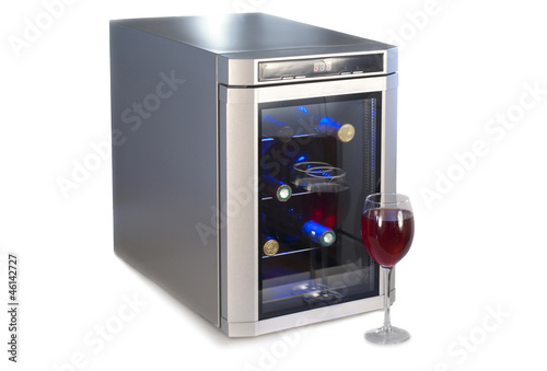 Photo: Wine refrigerator and glass of red wine. Wine refrigerator and glass of red wine.
