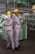 two industrial workers full length portrait in factory