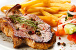 Grilled steaks, French fries and vegetables