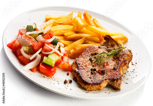 Photo: Grilled steaks, French fries and vegetables Grilled steaks, French fries and vegetables