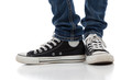 Photo: Vintage, antique athletic shoes on a white background with jeans Vintage, antique athletic shoes on a white background with jeans