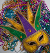 A yellow Mardi Gras mask and beads