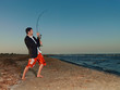 Photo: happy young businessman fishing by sea shore happy young businessman fishing by sea shore
