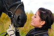 Young girl with her horse front of reed