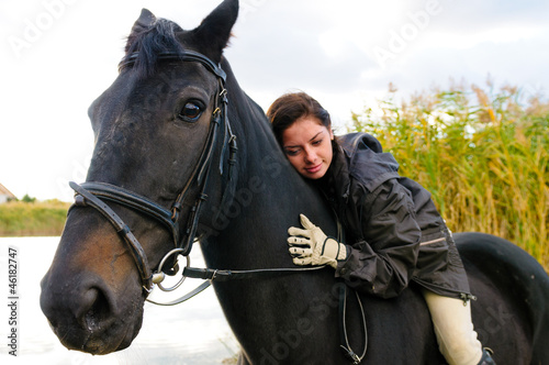 Photo: Pretty girl riding horse in shallow river water Pretty girl riding horse in shallow river water