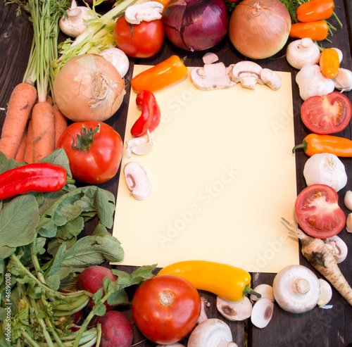 Photo: Orange paper for recipes on wood backround with vegetable Orange paper for recipes on wood backround with vegetable