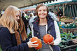 two young women looking at Hokkaido pumpkins