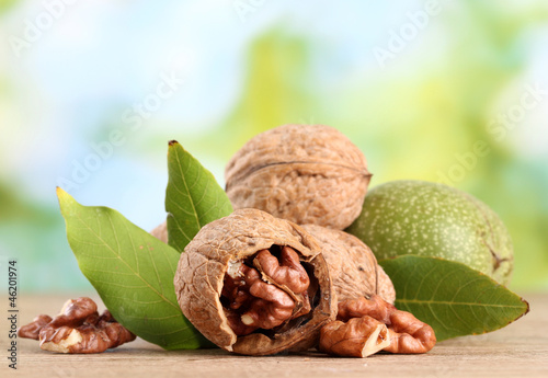 Photo: walnuts with green leaves, on green background walnuts with green leaves, on green background