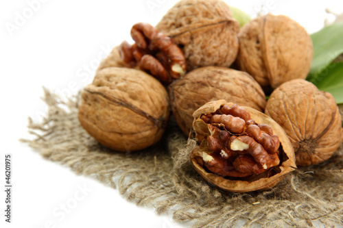 Photo: walnuts with green leaves on burlap, isolated on white walnuts with green leaves on burlap, isolated on white