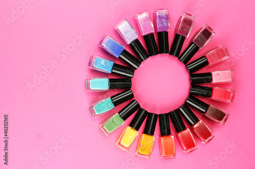 Photo: Group of bright nail polishes, on pink background Group of bright nail polishes, on pink background