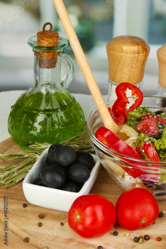 Photo: Fresh greek salad in glass bowl surrounded by ingredients for Fresh greek salad in glass bowl surrounded by ingredients for