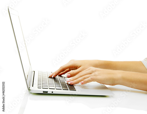 Photo: female hands writing on laptot, isolated on white female hands writing on laptot, isolated on white