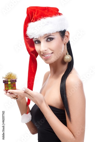 Photo: Woman in santa hat with Christmas present smiling Woman in santa hat with Christmas present smiling