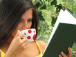 Joven mujer leyendo un libro,bebiendo café.