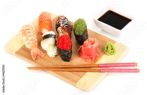 Photo: delicious sushi served on wooden board isolated on white delicious sushi served on wooden board isolated on white