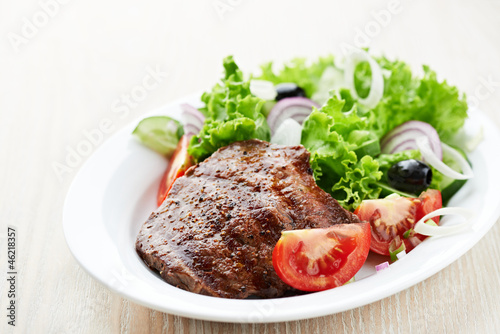 Photo: Grilled steak with fresh vegetables on a plate Grilled steak with fresh vegetables on a plate