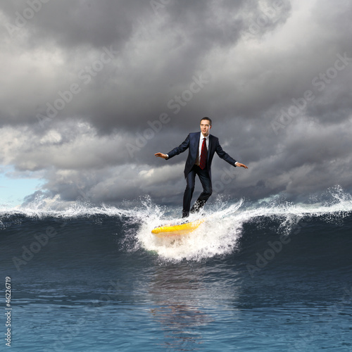 Photo: Young business person surfing on the waves Young business person surfing on the waves