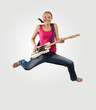 young woman playing on electro guitar and jumping