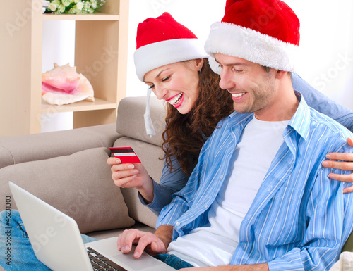 Photo: Young couple with laptop and credit card buying online Young couple with laptop and credit card buying online