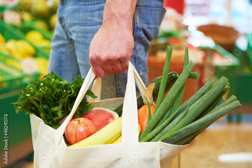 Photo: Mann mit Beutel im Supermarkt Mann mit Beutel im Supermarkt