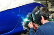 Worker welding car body.