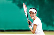 Woman in sportswear plays tennis at contest