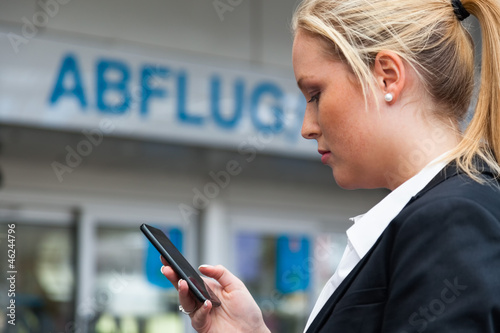 Photo: Frau schreibt SMS am Flughafen Frau schreibt SMS am Flughafen