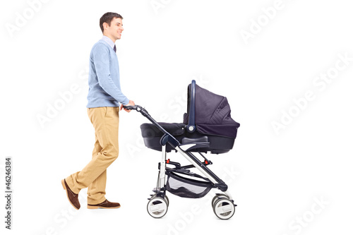 Photo: Full length portrait of a father pushing a baby stroller Full length portrait of a father pushing a baby stroller