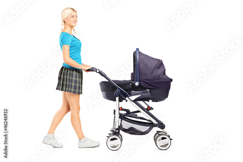 Photo: Full length portrait of a mother pushing a baby stroller Full length portrait of a mother pushing a baby stroller