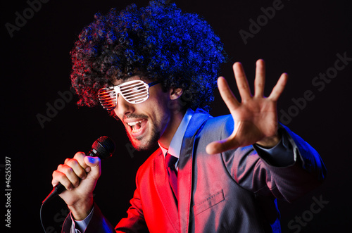 Photo: Young singer in afro wig singing at disco Young singer in afro wig singing at disco