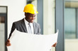 Photo: happy african american businessman looking at blueprint happy african american businessman looking at blueprint